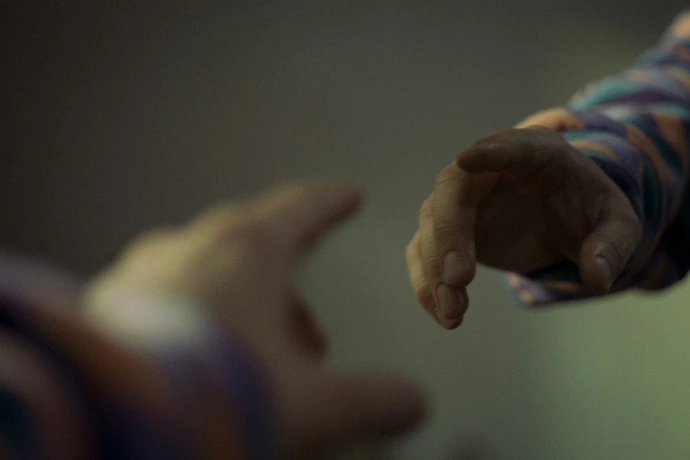 Two hands reaching towards each other